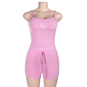 Close-up of pink ribbed knit camisole set with white letter embroidery on the chest