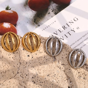 Hollow spherical stud earrings in 18K gold and silver plating on stone background