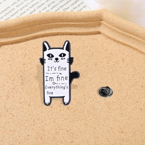 Cartoon enamel cat brooch pin with humorous everything is fine text on cork background