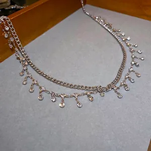 Double-layered silver body chain featuring minimalist Cuban links and sparkling tassels