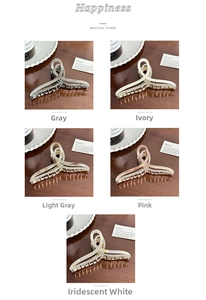 Detailed view of five acetate hair claws with rhinestones and mother-of-pearl texture