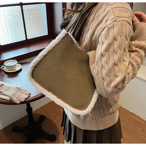 Detail of army green suede tote bag with faux shearling trim worn by model on shoulder