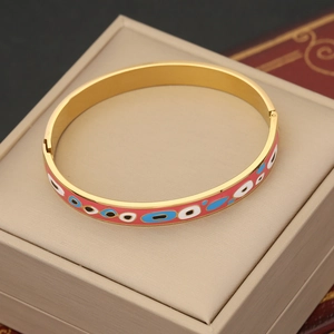Macro detail of vintage gold stainless steel bracelet with colorful enamel eye patterns