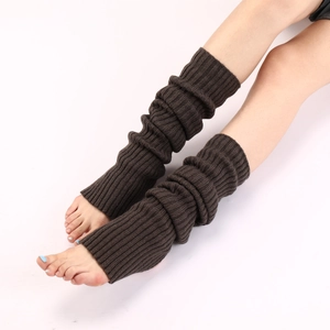 Detailaufnahme dunkelbrauner gestrickter Beinstulpen für Yoga mit Rippenstruktur am Bein