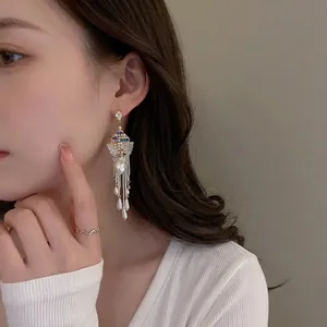 Luxurious tassel drop earrings with blue crystals and imitation pearls on model