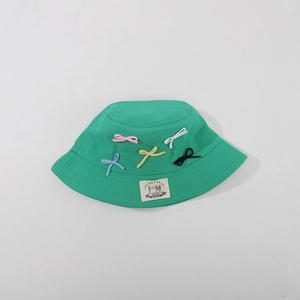 Detail of green cotton bucket hat with colorful bows and a square woven brand label