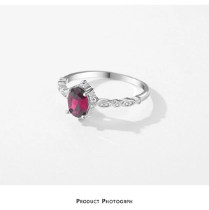 Macro view of vintage silver ring with oval pigeon blood red gem and diamond leaf setting