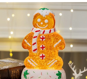 Close-up of a glowing gingerbread man figurine with golden glitter inside for Christmas