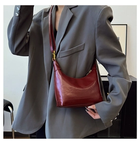 Detail view of red leather crossbody bag featuring embossed gaoihse lettering and strap