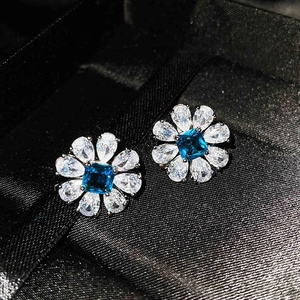 Macro view of blue topaz flower earrings with pear-cut crystal petals in silver