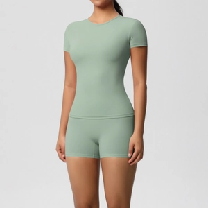Detail of sage green elastic yoga set featuring slim fit t-shirt and high waist gym shorts