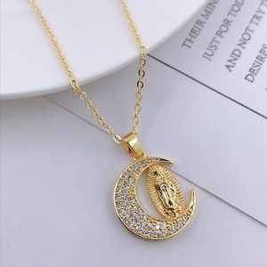 Close-up of gold moon necklace featuring Virgin Mary relief with white crystals