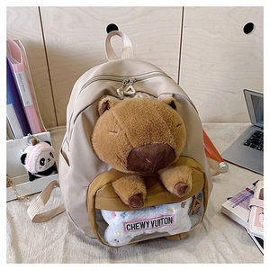 Detail of Capybara backpack on desk with plush accessory and transparent pocket
