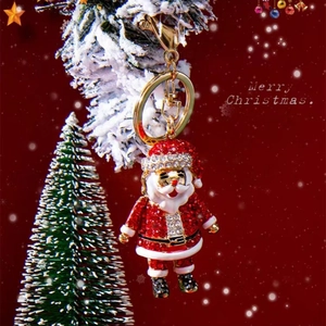 Sparkling Santa Claus keychain with red rhinestones and gold metal on festive background