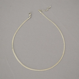 Detail of silver flat snake chain necklace with lobster clasp and adjustable metal extender
