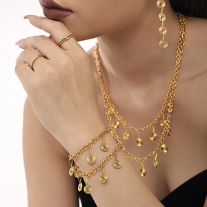 Golden stainless steel jewelry set featuring layered spiral coil necklaces and drop earrings