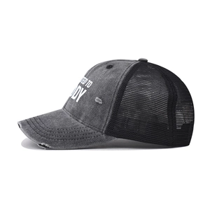 Side view of gray washed denim trucker hat with distressed details and mesh back