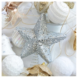 Macro detail of champagne gold glitter star and white beaded Christmas tree ornaments