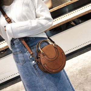 Retro brown circular crossbody bag in matte finish with metallic ring handles