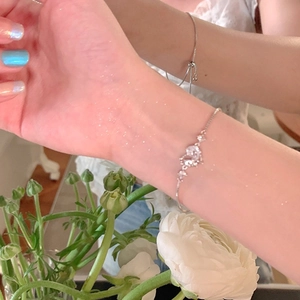 Macro shot of silver zircon heart bracelet with adjustable chain on female wrist