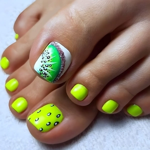 Macro view of kiwi fruit nail art on toenails with pink glitter and lime green polish