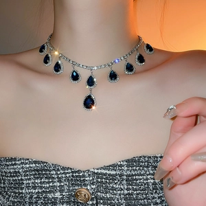 Dettaglio dell'elegante collana con pendente a goccia di zaffiro e cristalli su catena