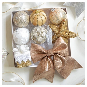 Detailed overhead view of champagne and gold Christmas ornament set with glitter bows and stars