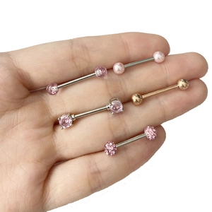 Détail de quatre piercings de mamelon roses avec boules pailletées et perles