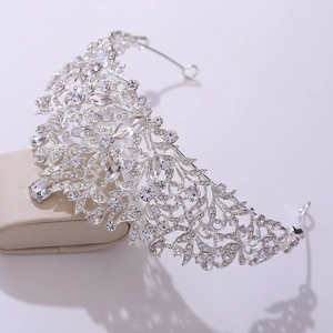 Close-up of a silver baroque crown featuring crystal leaf patterns and pear-cut rhinestones