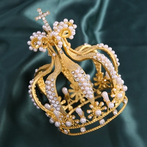 Gros plan d'une couronne de mariée dorée avec perles et strass sur tissu en soie verte