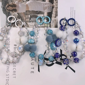 Handmade beaded phone charms with sparkling rhinestones and colorful faux fur pom-poms