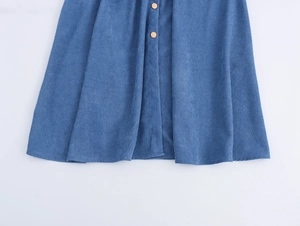 Detailed view of blue corduroy midi skirt featuring functional front button closure