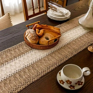 Close-up detail of beige and coffee woven table runner with textured knitted pattern