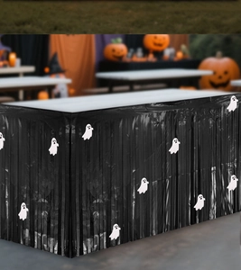 Detail of black fringe Halloween table skirt with white ghost patterns for party decor