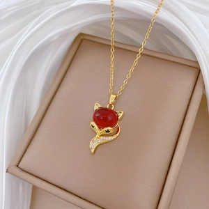 Macro shot of luxury red fox pendant with sparkling rhinestones and gold-tone chain