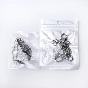 Detailed view of silver cross necklaces with sparkling zircon inlay in clear packaging