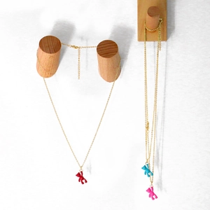 Three minimalist gold necklaces with colorful bear pendants in red, blue, and rose pink finish