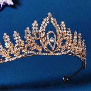 Luxurious golden bridal crown featuring rhinestone leaf patterns and teardrop crystal design