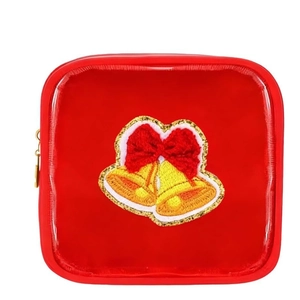 Detail of red chenille makeup bag featuring festive Christmas bell embroidery patch