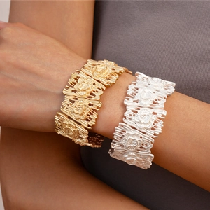 Matte gold and silver hollow floral wide cuff bracelets shown on model's wrist