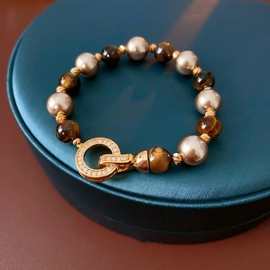 Macro shot of tiger eye beads and champagne pearls on a vintage gold plated bracelet