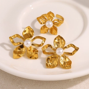 Elegant 18K gold-plated flower ring with white pearl detail on a ceramic display