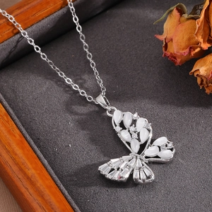 Macro view of silver bow necklace pendant with pearl shell and sparkling crystals