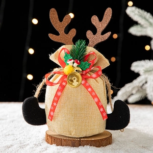 Sac cadeau de Noël en jute avec bois de renne et ruban flocon sur un fond de neige d'hiver