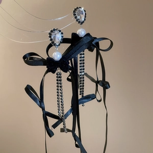 Détail de boucles d'oreilles nœud avec perles blanches et franges strass étincelantes