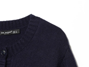 Close-up of neckline and ribbed knit texture on a navy blue women's cardigan