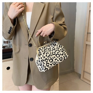 Close-up of leopard print evening clutch with gold chain and crystal bow detail