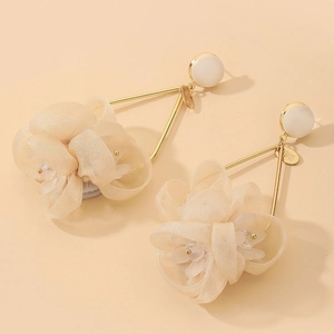 Close-up of beige fabric flower earrings with gold triangular frame and white studs
