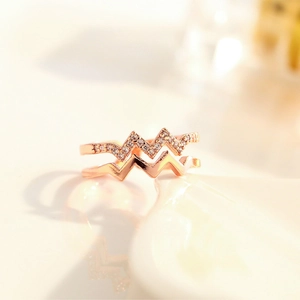 Macro shot of rose gold double-layer ring featuring wave-shaped bands and micro-set crystals
