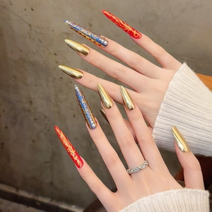 Luxurious long stiletto press-on nails with golden metallic finish and pearl rhinestone accents
